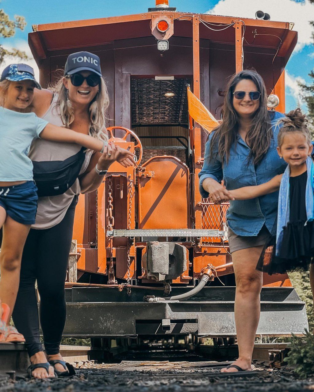 Two girls and their moms on caboose of Leadville train by @ashesnfo