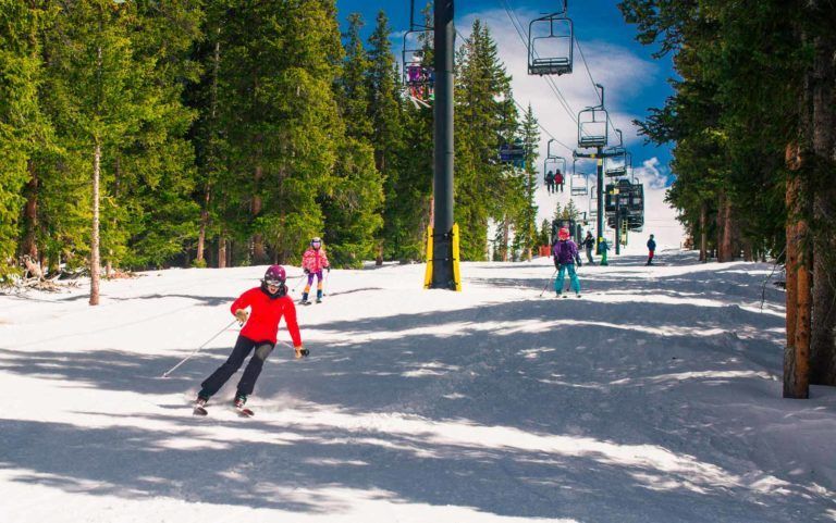 Skiers in colorful clothes skiing downhill at Cooper
