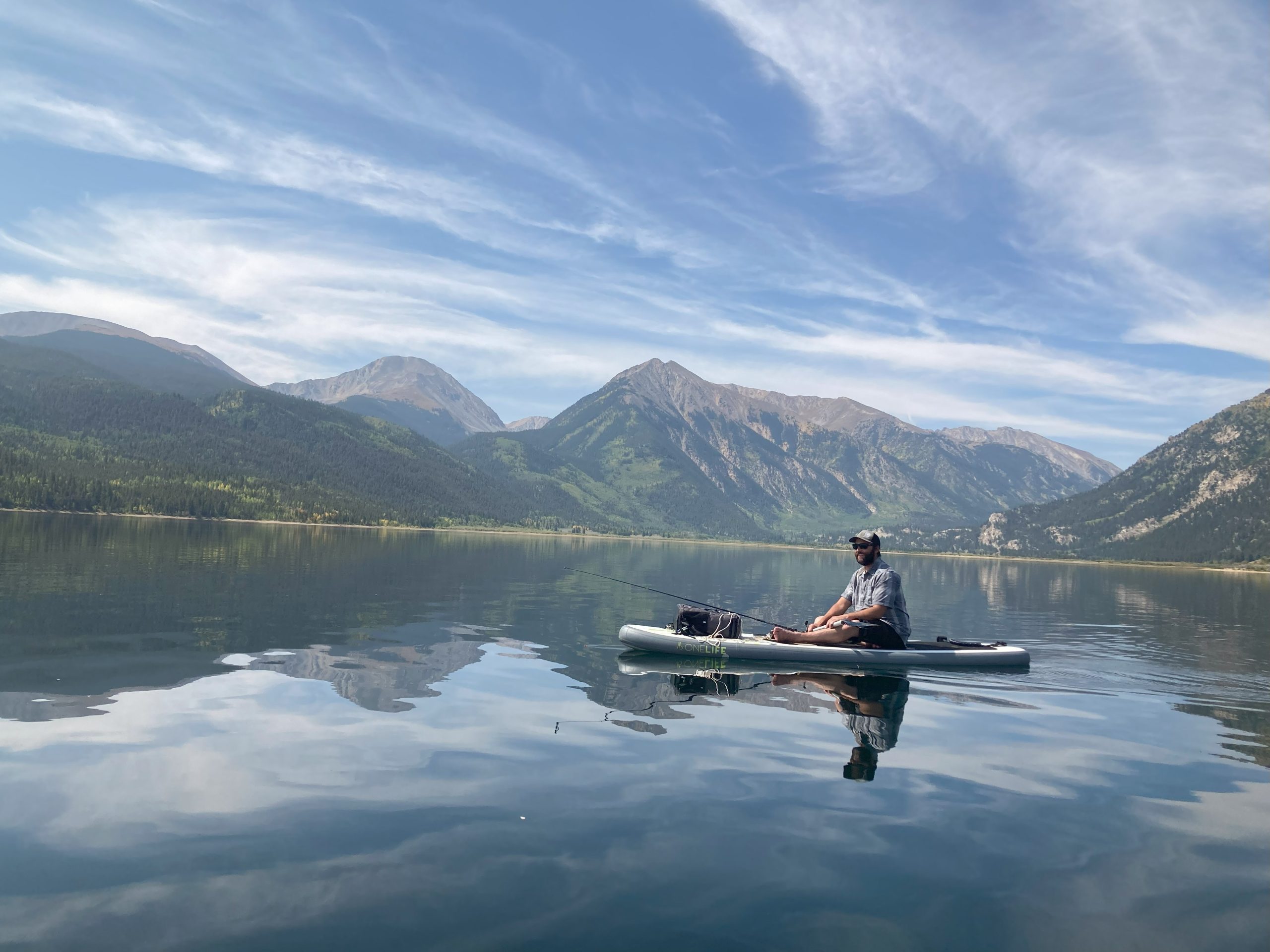 A man fishing from a paddleboard on a beautiful day at Twin Lakes